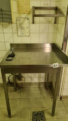 a metal table with a drain in the middle of it