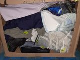a cardboard box filled with clothes and clothes on the floor