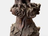 an image of a statue of an eagle sitting on a tree stump