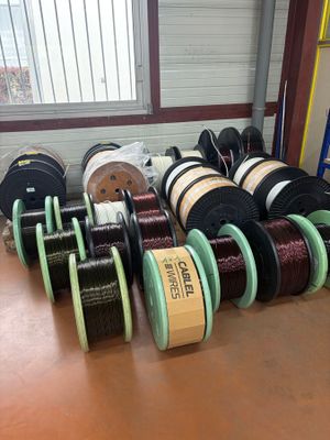 many spools of different colors and sizes on the table