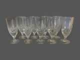 six verres à vin sont alignés sur une surface grise