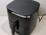 a black air fryer sitting on a counter top