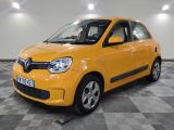 the small yellow car is parked in the garage on a checkered floor