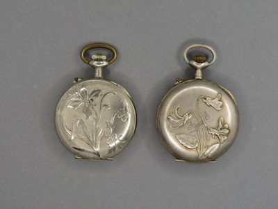 deux boucles d'oreilles en argent ornées de fleurs et de feuilles, sur un fond gris