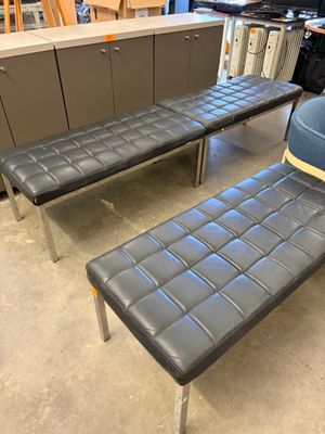 deux bancs en cuir noir et une chaise bleue dans une pièce