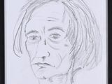 drawing of a woman ' s face in a black frame on a table