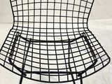the wire chair is on a white sheet on the floor