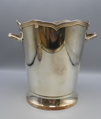 an antique silver plated ice bucket with handles on a stand