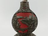 a red vase with a dragon on it on a table