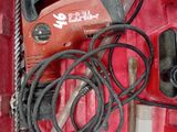 a red box with tools in it that include a cord saw, hammer, and other tools