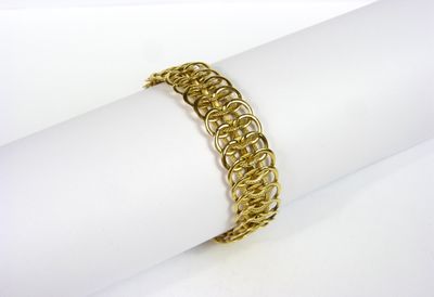 un gros plan d'un bracelet plaqué or posé sur une serviette