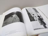 an open book with a black and white photo of a man on a bicycle
