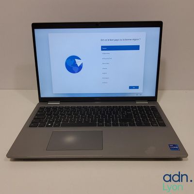 un ordinateur portable ouvert posé sur une table blanche