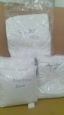 trois sacs contenant des oreillers blancs posés sur une boîte en carton