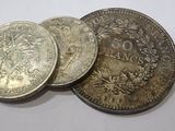 three silver coins sitting on top of each other on top of a table