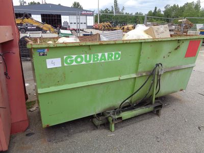 a green dumpster sitting in the middle of a parking lot