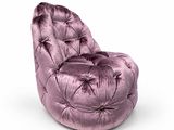 fauteuil en velours violet posé sur une surface blanche, avec un fond blanc