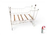 a white iron bed with wooden slats on it