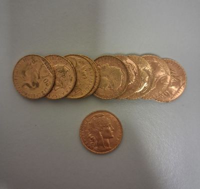 cinq pièces d'or posées sur une surface blanche