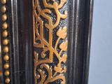 a close up of a clock with gold decorations on it