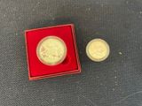a small gold coin in a red box next to a smaller gold coin