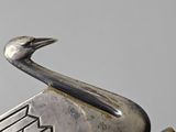 a person holding a metal object with a bird on it