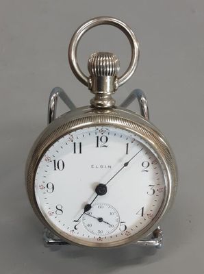 a silver pocket watch that is on display on a table