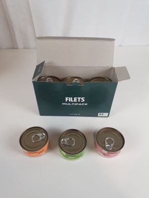 quatre boîtes de conserve dans un carton posé sur une table
