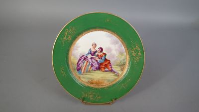 une image représentant une assiette verte sur laquelle est peinte une scène représentant un homme et une femme