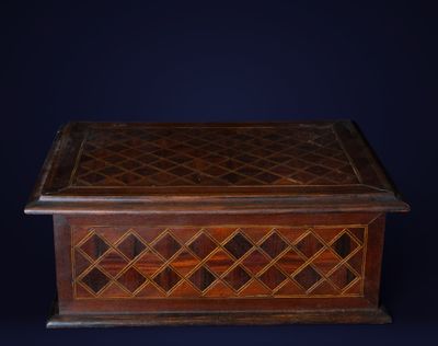 une boîte ancienne en bois dont le couvercle est orné d'un motif en treillis