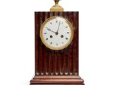 a wooden clock that is on a stand with a white background