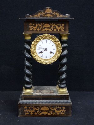 a clock that is sitting on a stand on a black background