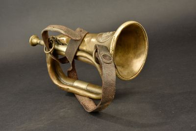 an old brass trumpet with a leather band on a black background