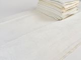 une pile de serviettes pliées posée sur une table blanche