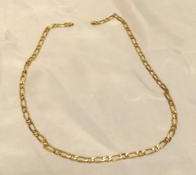 un collier à chaîne en or sur fond blanc