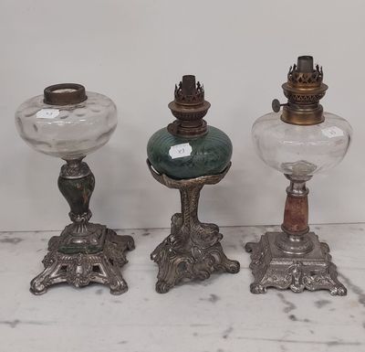 trois lampes anciennes en verre posées sur une table blanche