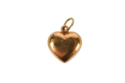 a close up of a gold heart charm on a white background
