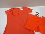 an orange shirt and shorts sitting on top of a white table