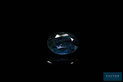 a close up of a blue diamond on a black surface