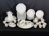 many plates and cups on a table with a black background