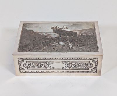 une vieille boîte en argent ornée d'un cerf, posée sur une table