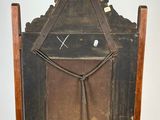 an old wooden chair with a clock on it