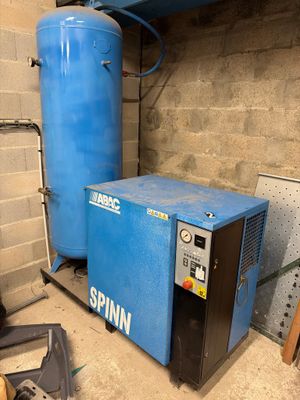 une machine bleue posée à côté d'un réservoir bleu dans une pièce