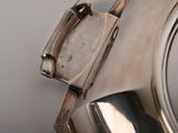 a close up of a silver plate with a handle on it