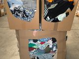 deux cartons sur lesquels sont posés des vêtements, dans un entrepôt