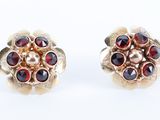 une paire de boucles d'oreilles ornées de grenats rouges sur fond blanc