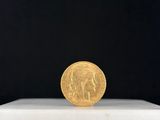 une pièce d'or posée sur un socle blanc