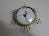 a gold clock with a white face on a white table