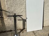 a white door sitting next to a metal pole on the sidewalk