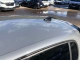 many cars parked in a parking lot in the rain